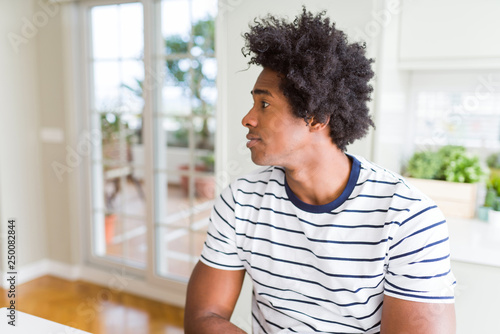 African American man wearing stripes t-shirt looking to side, relax profile pose with natural face with confident smile.