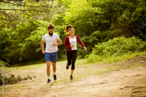 Fototapeta Naklejka Na Ścianę i Meble -  Healthy fit and sportive couple running in nature