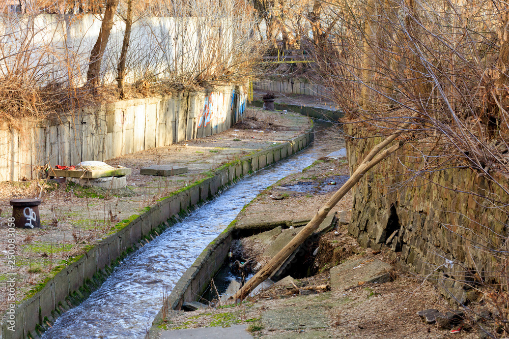 The dirty river Lybid flows along a channel enclosed in a concrete chute. The dirty river Lybid flows along a channel enclosed in a concrete chute.
