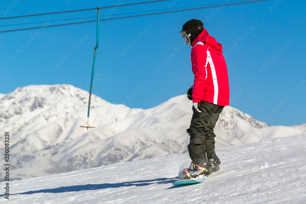 snowboarder quickly rolls down the mountain in loose snow against a blue sky on a sunny day. Copy space snowboarder quickly rolls down the mountain in loose snow against a blue sky on a sunny day. Copy space