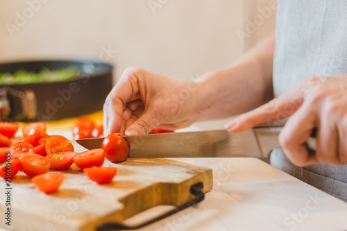 Close up of senior woman hands cutting baguette - making sandwich bruschetta - home cooking