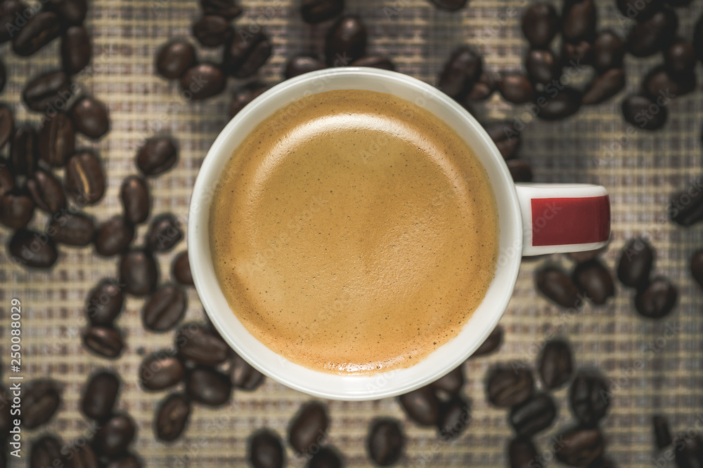 cup of coffee with beans on wooden table. coffee top view. cup of coffee with beans on wooden table. coffee top view.