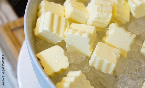 Cubes of fresh butter placing on ice in white bowl. Hotel restaurant breakfast buffet