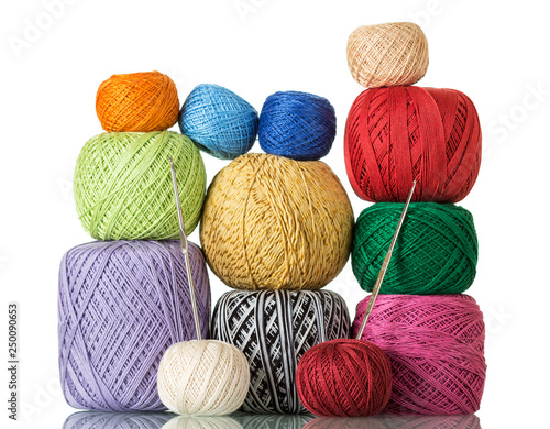 Various colorful skeins of wool yarn and crochet hooks