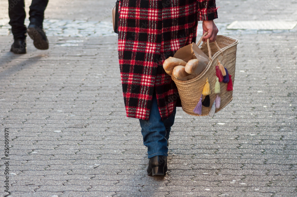 portrait of woman walking in the street with bread in her basket