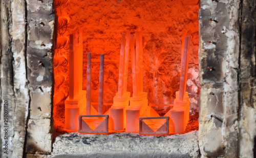 Red hot parts in an electric furnace for hardening metal. Hardening of metal parts at the valve manufacturing plant. Dangerous work, close up