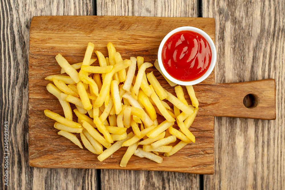 French fries with ketchup on wooden background French fries with ketchup on wooden background