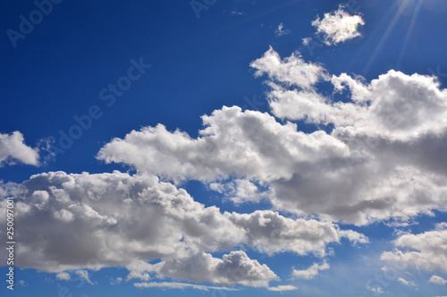 Bright Blue Sky with Clouds and Sunlight Rays