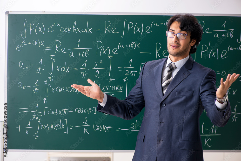 Young male math teacher in classroom 