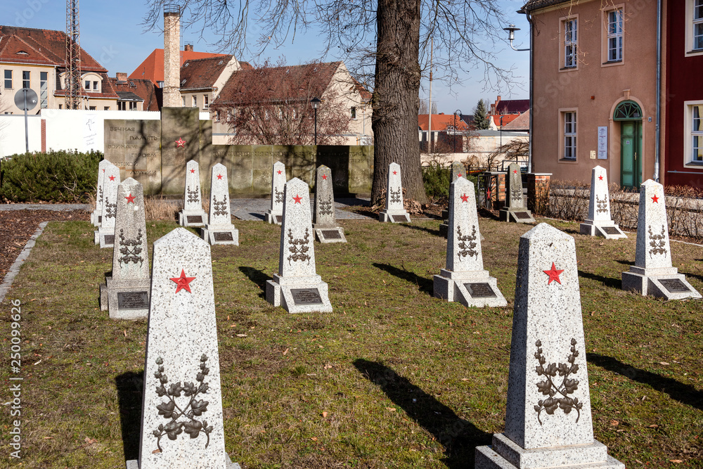 Germany, Brandenburg, Jueterbog: Public Soviet memorial park with central  memorial stones, hammer and sickle in red star, epigraphs, blue sky in the  center of the German small town. Stock Photo | Adobe