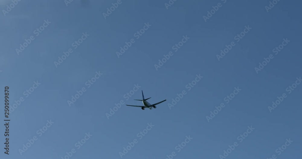 White airplane is flying in the blue sky. Business trip. Copy space. White airplane is flying in the blue sky. Business trip. Copy space.
