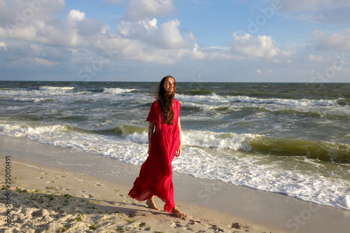 Woman in red on the sea coast