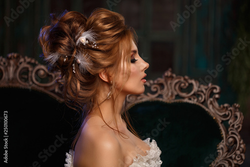 Luxury model in vintage style. Beautiful woman with a stunning hairstyle and make-up in a rococo dress. Girl at the Masquerade Spring Ball