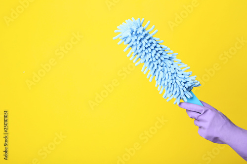 Female hand holding cleaning wipe on yellow background