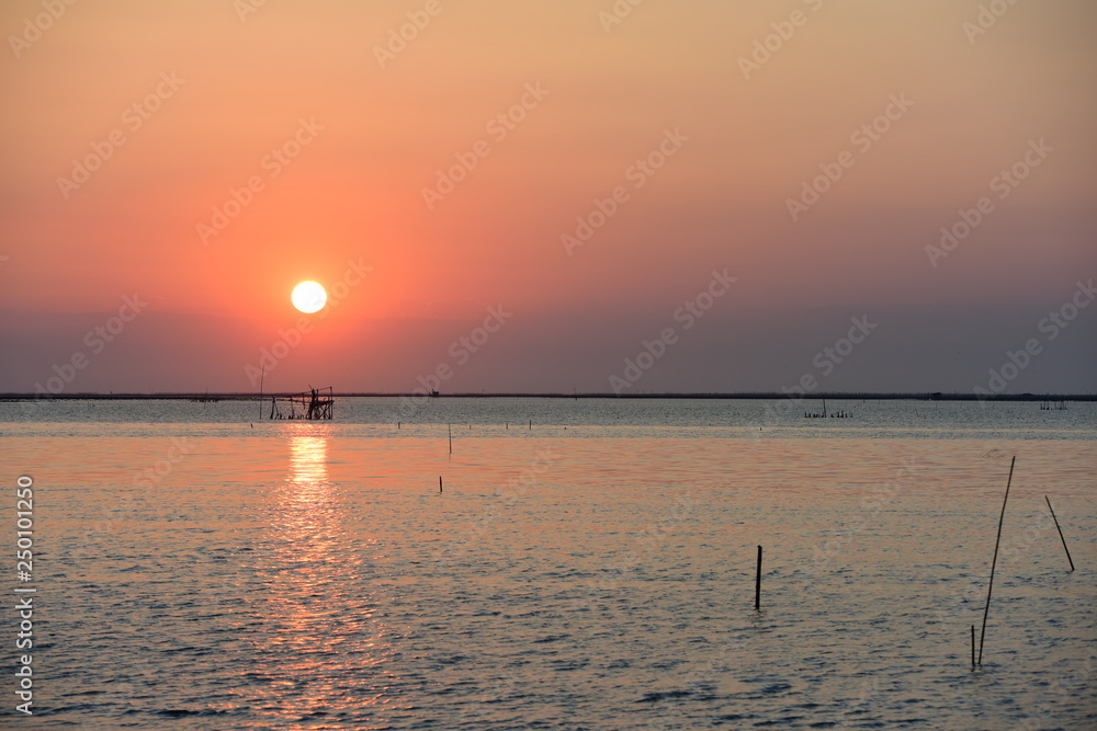 Sunset and golden yellow sky At the beautiful beach at the sea of ​​Chonburi, Thailand is used as a background image.