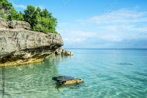 Rocky coast of Bantayan Island in Philippines with clear sea water and tropical beach photo