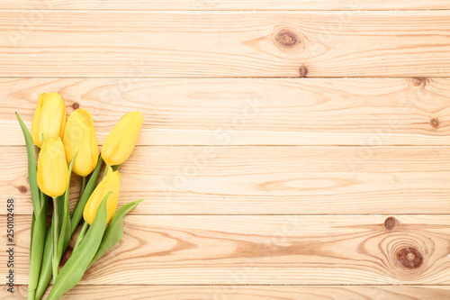 Bouquet of yellow tulips on brown wooden table