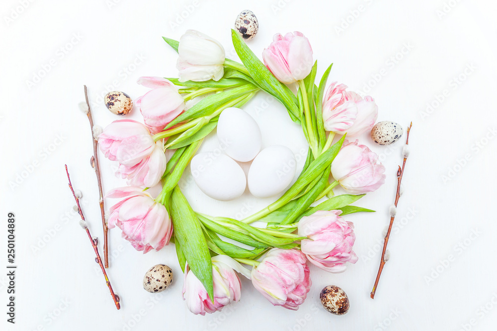 Spring greeting card. Easter eggs in nest and pink fresh tulip flowers bouquet on rustic white wooden background. Easter concept. Flat lay top view copy space. Spring flowers tulips Spring greeting card. Easter eggs in nest and pink fresh tulip flowers bouquet on rustic white wooden background. Easter concept. Flat lay top view copy space. Spring flowers tulips