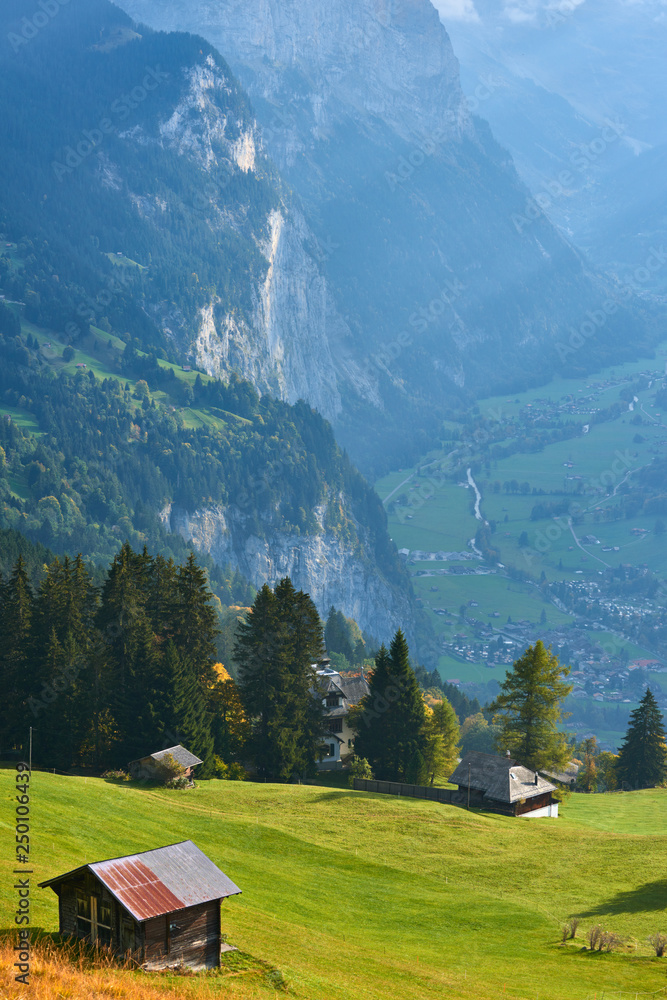 Scenery of the gorgeous mountain valley with the old barn and green meadows at foreground. Near Wengen village in Switzerland. Scenery of the gorgeous mountain valley with the old barn and green meadows at foreground. Near Wengen village in Switzerland.