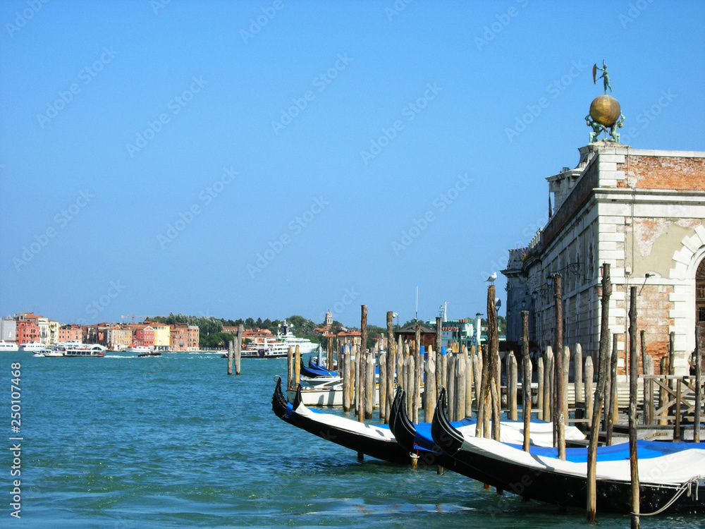 Grand canal in Italy, Venice at sunset with gondolas in the background and cloudless sky