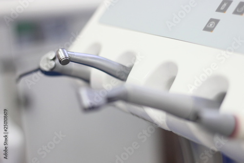 Professional dentist tools for teeth drilling and ultrasonic cleaning - medical equipment on table in dental office, close up blurred side view