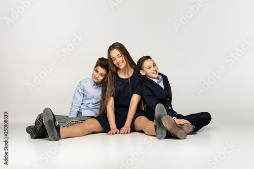 Young beautiful teenagers sitting together on the ground