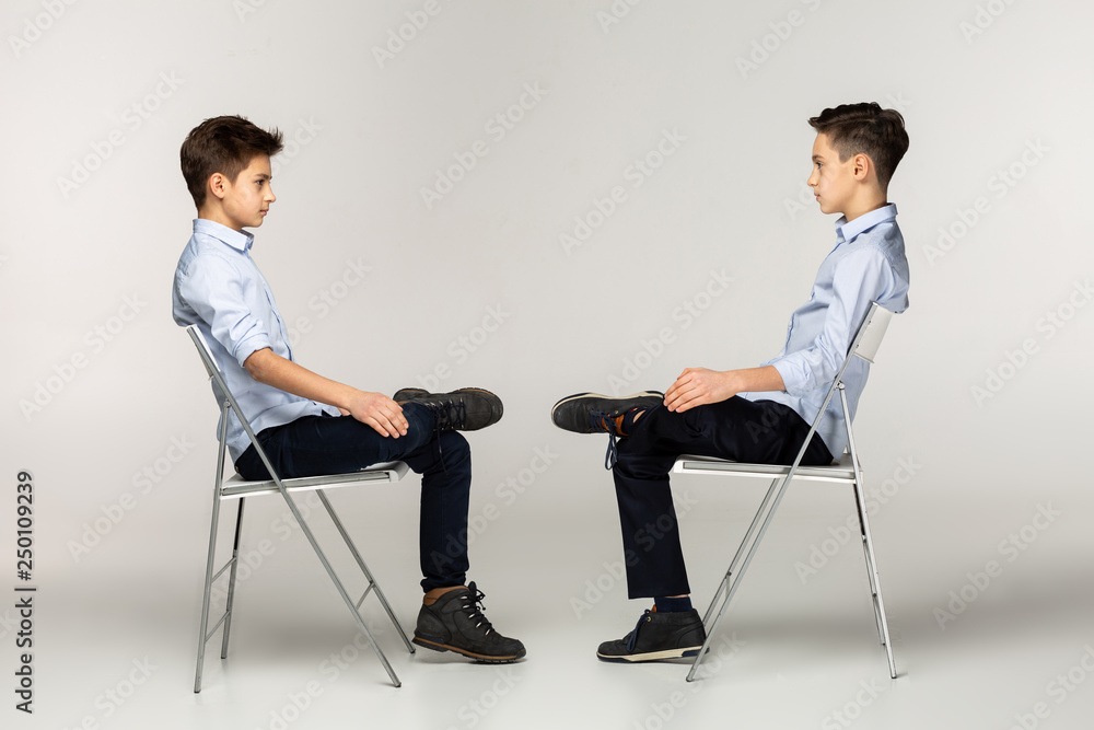 Obraz premium Side view portrait of two teenagers in blu shirts