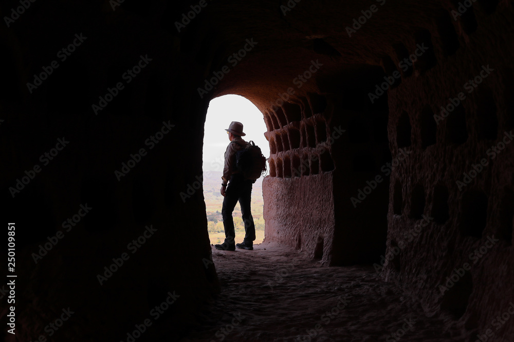 BOY MOUNTAINEER AND ADVENTURER AT THE ENTRANCE OF A CAVE OF AN OLD DOVECOTE