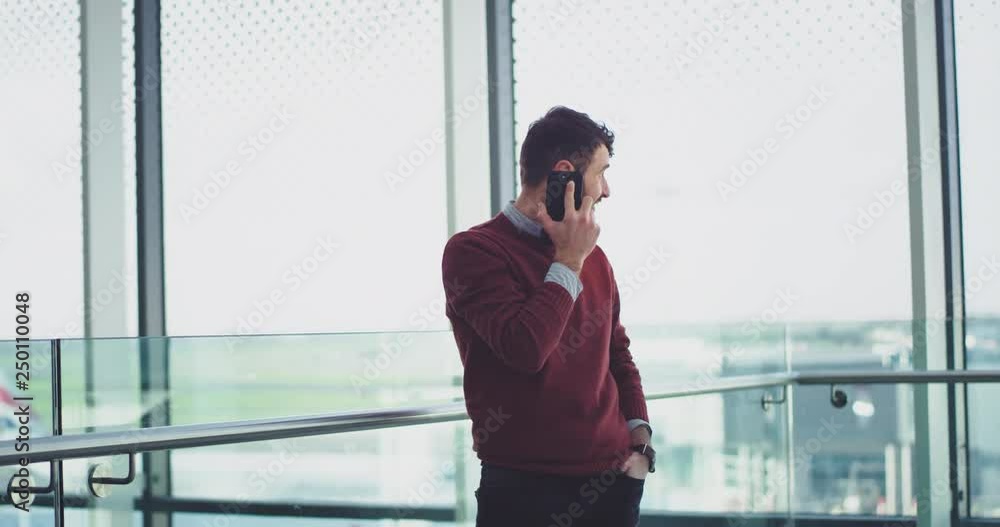 Good looking man in a business building speaking on his smartphone , beside of a big window view. Good looking man in a business building speaking on his smartphone , beside of a big window view.