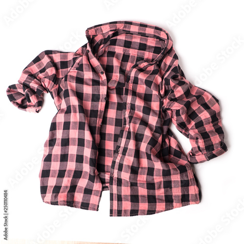 Plaid pink shirt on yellow hangers on a white background.