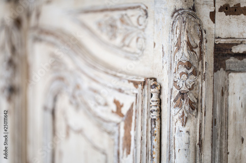 Vintage chest of drawers with carving white color with fading and metal handle. Close-up. Selective focus photo