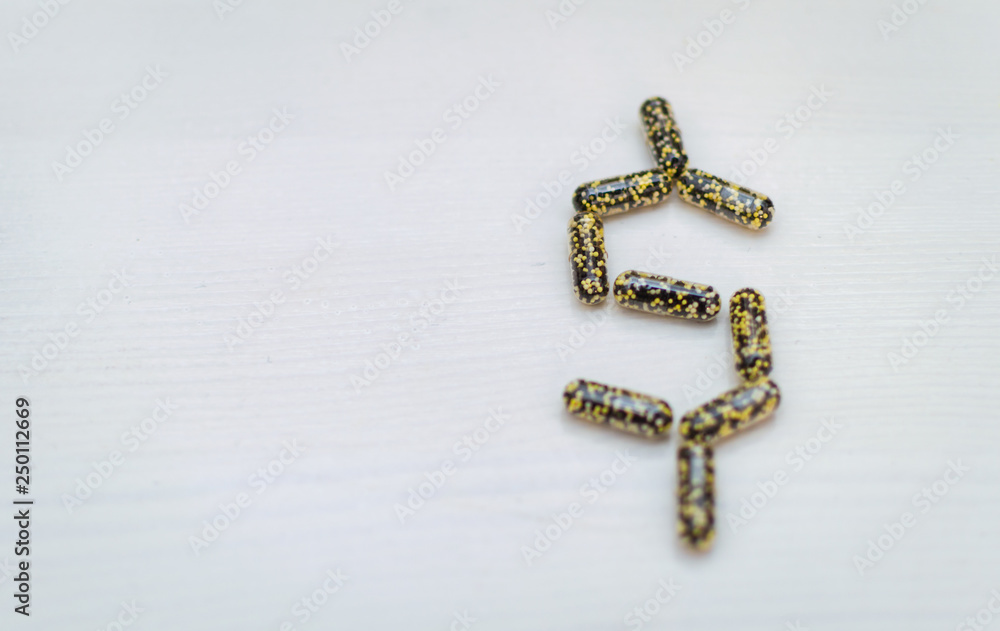 Scattered capsules on a white, wooden background Scattered capsules on a white, wooden background