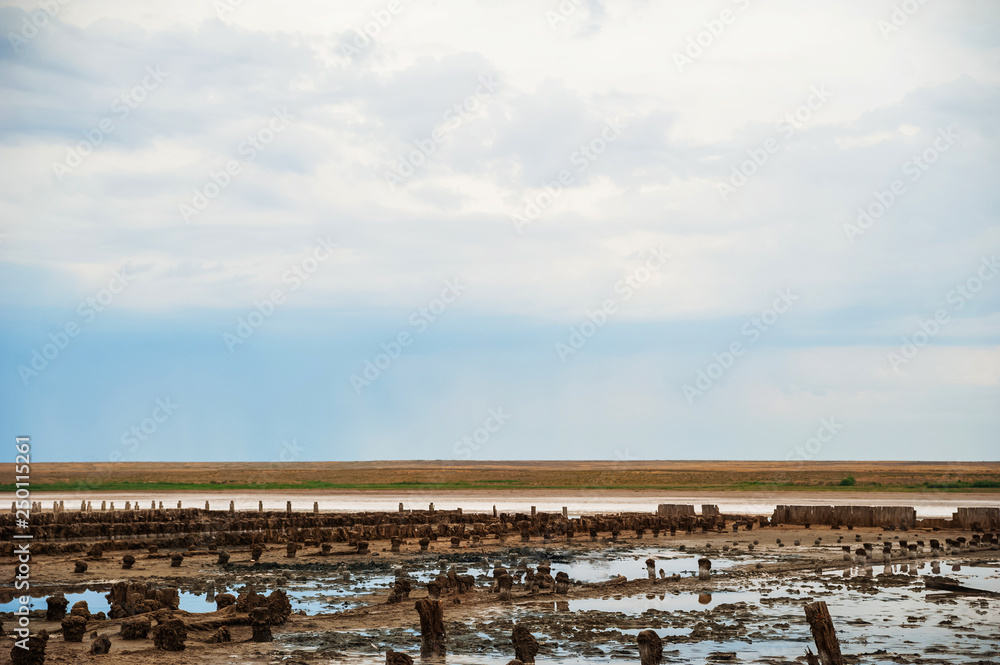 Beautiful natural textural background on a salt lake, river. Salt lake Elton, Russia, before rain and thunder, sunset on the water, solitude, silence, calm