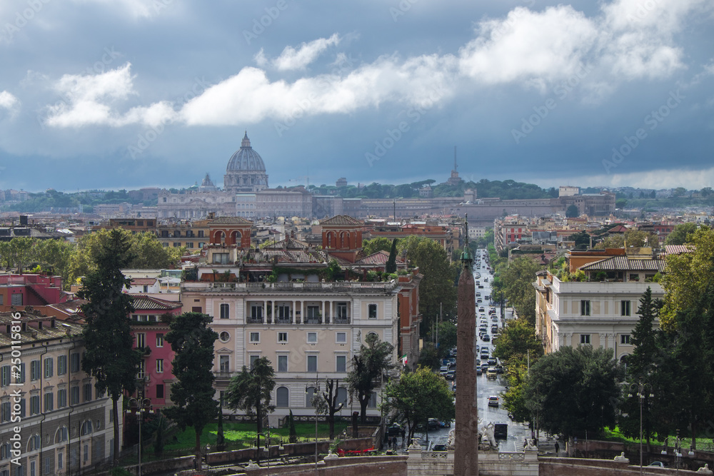 Obraz premium The view of Rome with Sain Peter's Dome in the distance under the grey stormy and cloudy sky, shot from a high point - Terazza del Pincio