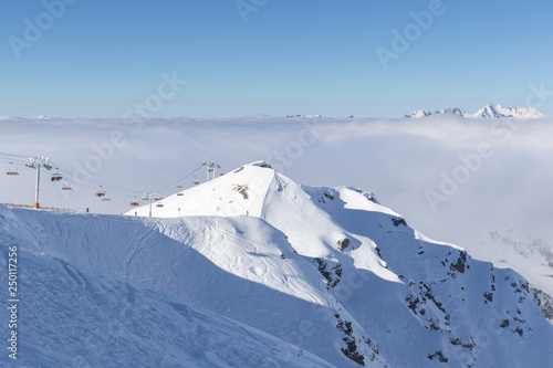 Mountain peaks covered in snow above clouds in La Plagne, French Savoy Alps. photo