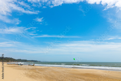 People on the sunny beach relax and get ready for kitesurfing