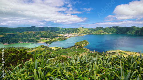 Lagoa Verde and Lagoa Azul, two connected lakes in wide volcanic caldera called Sete Cidades, filled by tropical greenery, located on Sao Miguel island of Azores, Portugal.