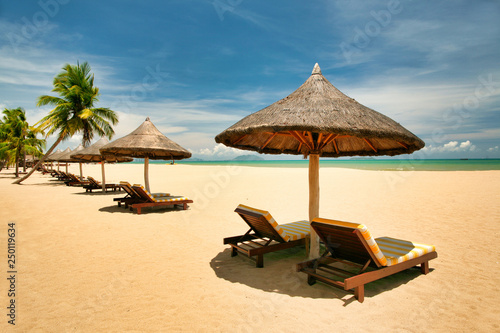 Many empty sun loungers on the deserted beach of Hainan Island.