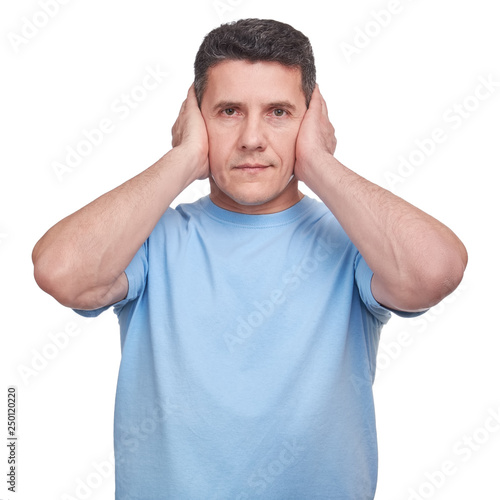 Portrait adult man closing his ears with two hands. He is afraid to hear about bad things or problems.
