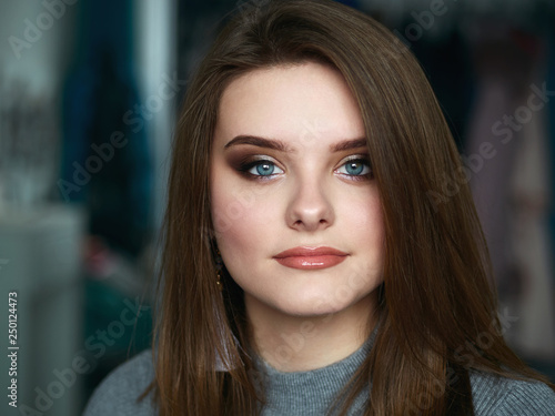 Young beautiful woman with professional make up and hairstyle with domestic room blurry background © sergeyzapotylok