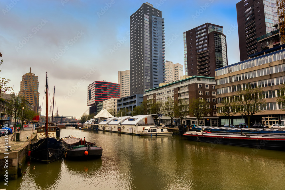 ROTTERDAM, NETHERLANDS - APRIL 13, 2018: Ships on river of the city Rotterdam. Buildings on background.