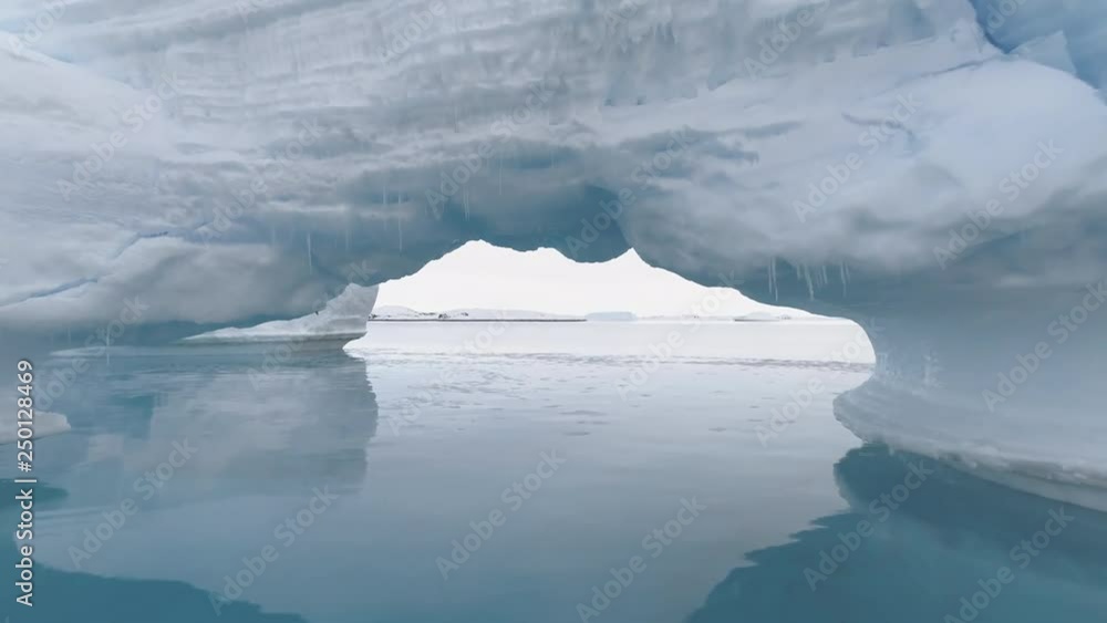Passing Through Arctic Iceberg Arch in Clear Water. Antarctica Wilderness Snow Covered Majestic Landscape Scenery. Expedition to Massive Blue Ice Mountain Shot Footage 4K (UHD) Passing Through Arctic Iceberg Arch in Clear Water. Antarctica Wilderness Snow Covered Majestic Landscape Scenery. Expedition to Massive Blue Ice Mountain Shot Footage 4K (UHD)