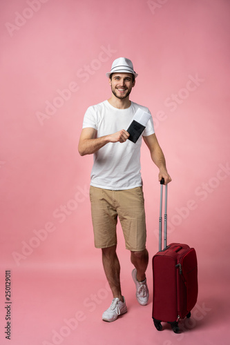 Man traveler with suitcase, passport and ticket on color background.