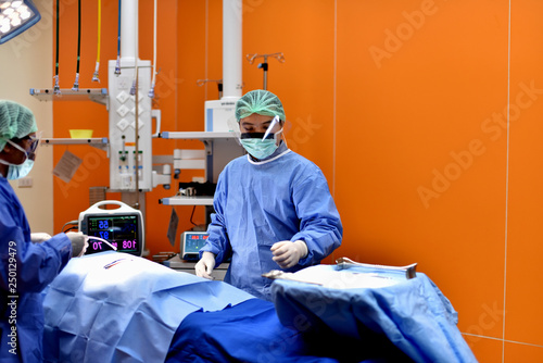 Medical Team Performing Surgical Operation in Modern Operating Room. Equipment and medical devices in hybrid operating room.scrub nurse preparing medical instruments for operation.