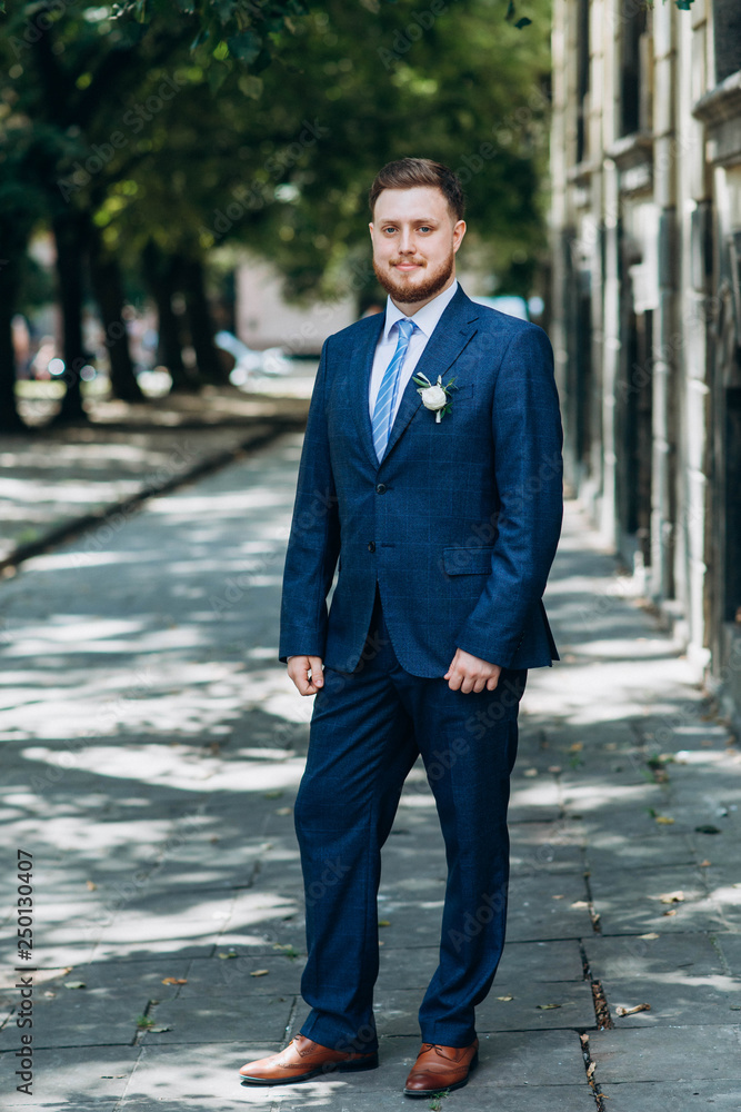 Handsome redhead bearded young groom in blue suit outside Handsome redhead bearded young groom in blue suit outside