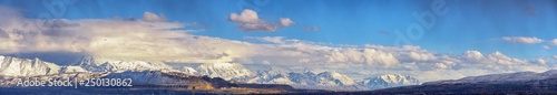 Winter Panoramic view of Snow capped Wasatch Front Rocky Mountains, Great Salt Lake Valley and Cloudscape from the Bacchus Highway. Utah, USA.