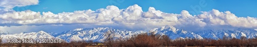 Winter Panoramic view of Snow capped Wasatch Front Rocky Mountains, Great Salt Lake Valley and Cloudscape from the Bacchus Highway. Utah, USA.