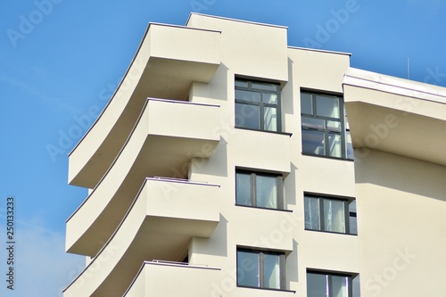 Modern white building with balcony on a blue sky