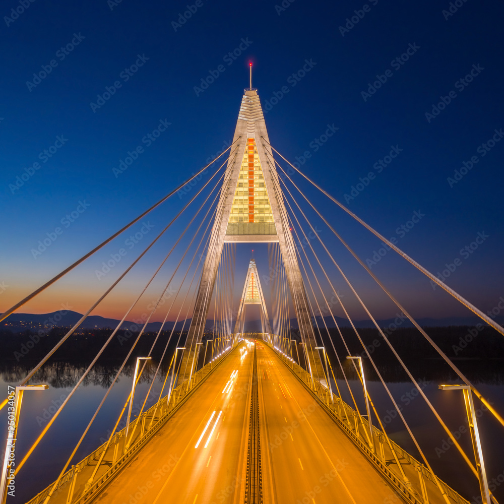 Obraz premium Budapest, Hungary - Aerial view of the illuminated Megyeri Bridge at blue hour