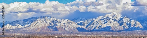 Winter Panoramic view of Snow capped Wasatch Front Rocky Mountains, Great Salt Lake Valley and Cloudscape from the Bacchus Highway. Utah, USA. photo
